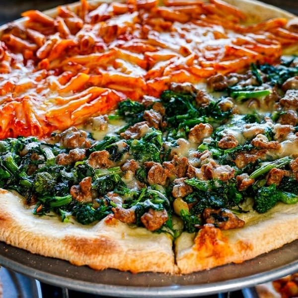 A pizza with two distinct halves: one with penne pasta and red sauce, the other with sausage and broccoli rabe.